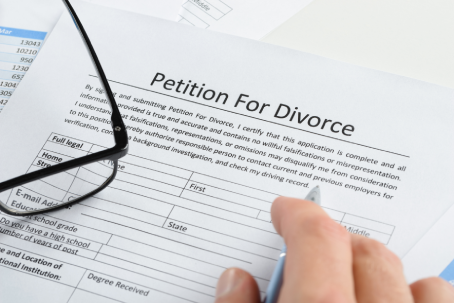 Close-up Of Hand With Pen On Petition For Divorce Paper